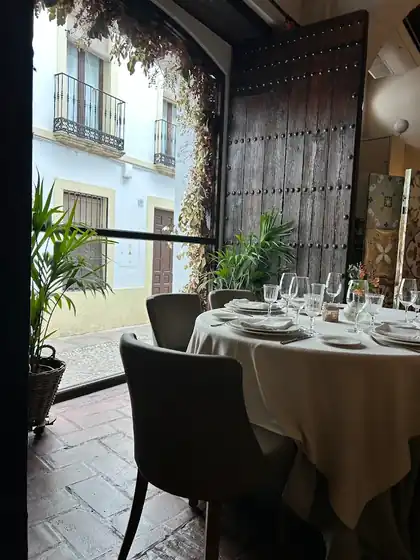 Gran puerta de madera y mesa del comedor de La Ermita de la Candelaria, Córdoba