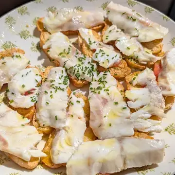 Tostas de lubina sobre pan crujiente en La Ermita de la Candelaria, Córdoba